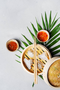 中国传统的蒸饺点心竹蒸锅酱和筷子，背景浅