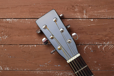 乐器头顶钉头黑色声学吉他在木材背景。