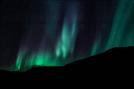 挪威北部令人惊叹的极光林格瓦索伊，背景是山脉和海洋