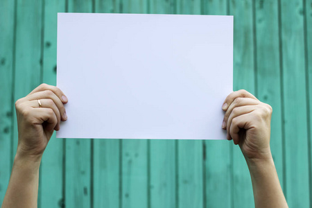 女人双手举过头,手里拿着一张白纸照片