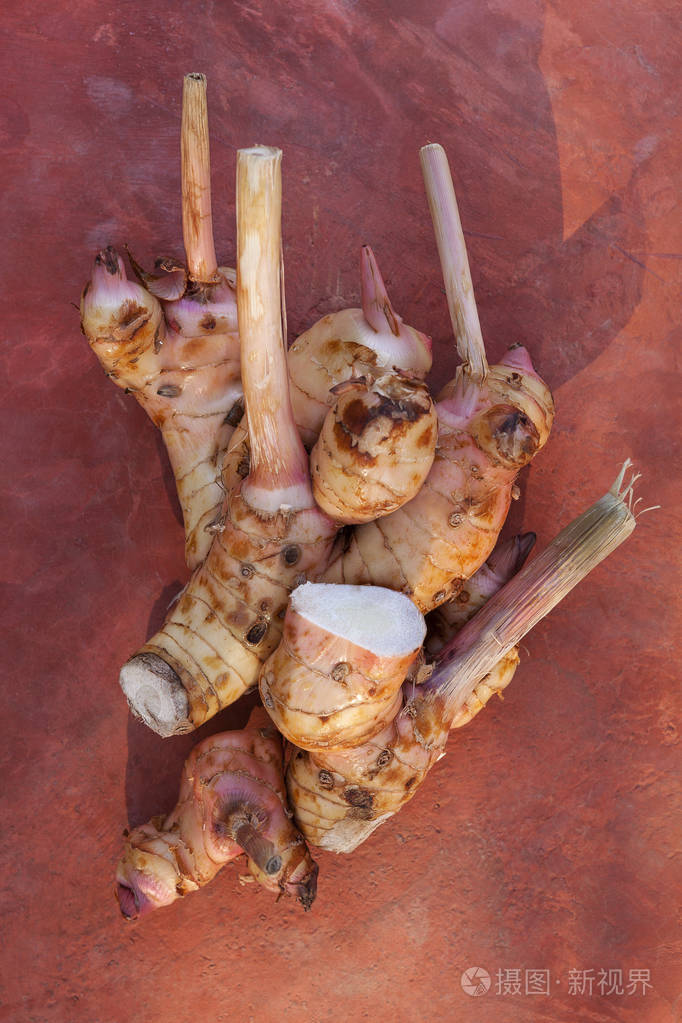 红色背景上的新鲜有机galangalalpiniagalanga顶部视图