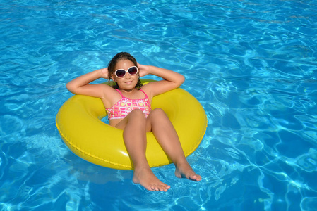 真正可爱的女孩放松游泳池暑假概念