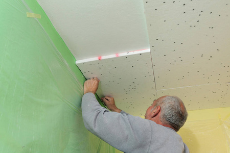 室内工程的天花板上发泡胶板建筑商在房屋墙上安装硬质发泡胶隔热板在