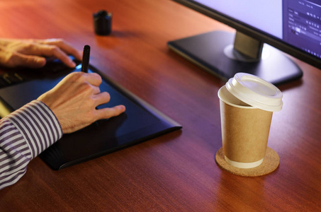 桌面侧视图。 电脑图形平板杯咖啡手。 网站横幅模型背景介绍和营销材料的概念