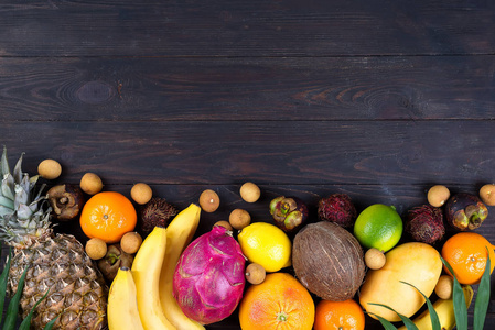 健康彩虹热带水果框架与棕榈叶在蓝色木桌上, 顶视图, 复制空间