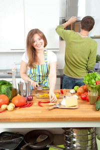 幸福的年轻夫妇一起在厨房准备健康的食物。 健康食品概念