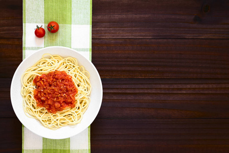 传统意大利意大利面条意大利面条意大利面条意大利面条加番茄酱在碗中拍摄黑暗的木材与自然光。