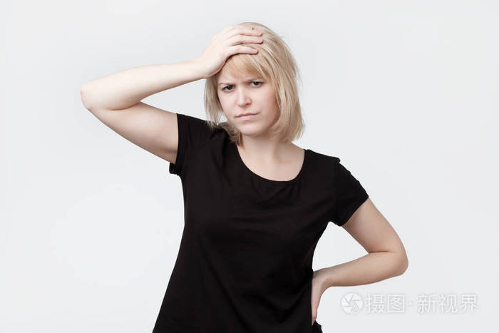 美丽的年轻金发碧眼的女人抓头