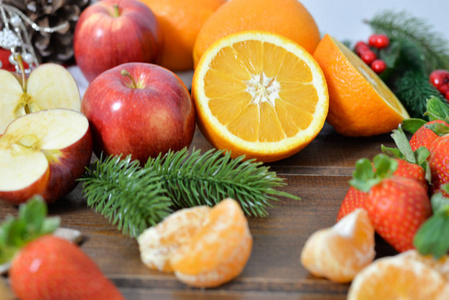 木制背景上的水果。 柑橘类水果，以乡村为背景，柑橘，草莓，曼达林，苹果。 健康饮食和节食的概念。 冬季品种
