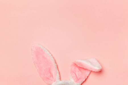 快乐复活节的概念。 为假期做准备。 装饰兔子耳朵毛茸茸的毛茸茸的服装玩具孤立在时髦的粉彩背景上。 简单的极简主义，平面，俯视图，