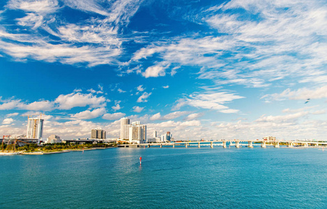 美国迈阿密市区的摩天大楼在多云的天空。海景与桥梁和建筑物在海上地平线上。结构和结构设计。暑假和旅行