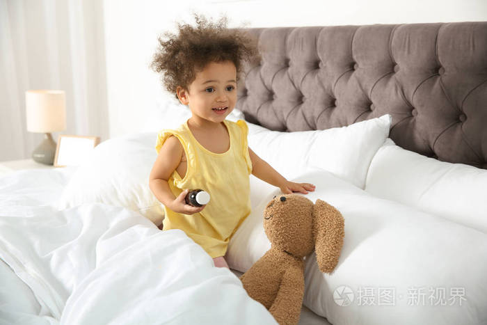 可爱的非裔美国儿童想象自己是医生，同时在家玩玩具兔子