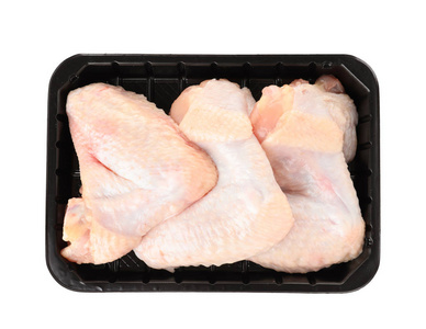 塑料容器与生鸡翅在白色背景顶部视图。 新鲜肉