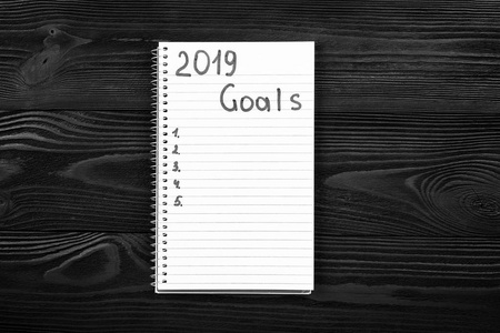 他笔记本上的2019年目标。 新年决议概念。 上面的风景。