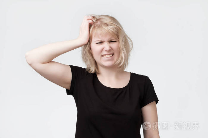美丽的年轻金发碧眼的女人抓头
