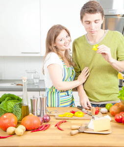 幸福的年轻夫妇一起在厨房准备健康的食物。 健康食品概念