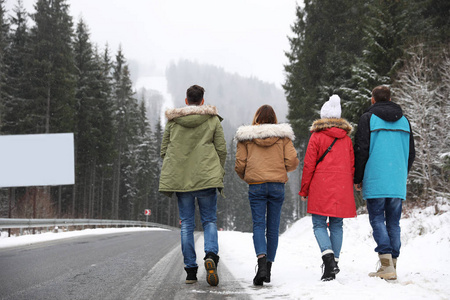 一群兴奋的朋友带着背包在寒假期间欣赏山景