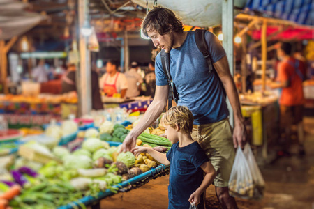 爸爸和儿子是亚洲食品市场步行街上的游客