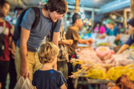 爸爸和儿子是亚洲食品市场步行街上的游客