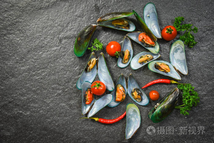 贝壳贻贝烹饪海鲜盘与贝类绿色贻贝海洋美食晚餐与草药和香料在暗石