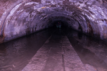 地下半圆形隧道。 黑暗的隧道。 中间的路径。