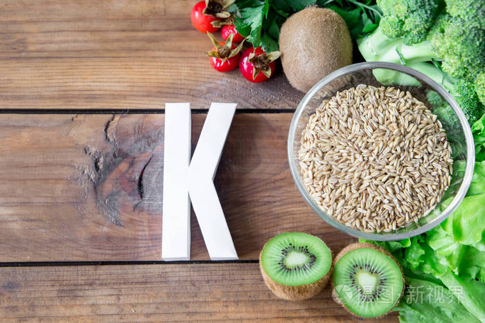 在木板上含有维生素k和字母k的最高食物健康饮食顶视图