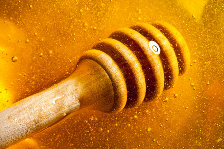 金色的蜂蜜从勺子里流下来。健康食品理念。健康饮食。饮食。选择性对焦。带复制空间的背景