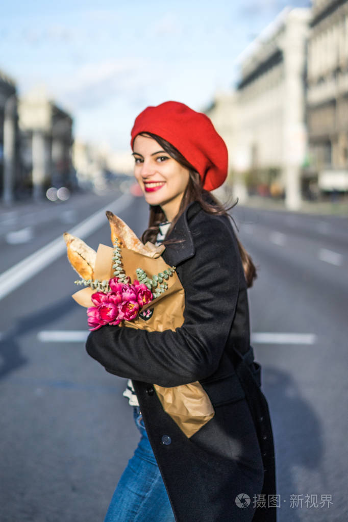 年轻美丽的女孩法国女人黑发穿着红色贝雷帽和黑色外套沿着欧洲城市的