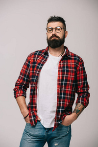 一个自信的留着胡须的男人，穿着灰色的格子衬衫摆姿势