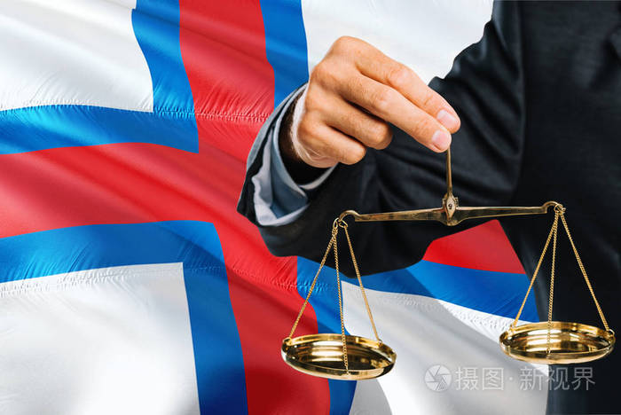 法官拿着金色的正义天平,法罗群岛挥舞着国旗背景.