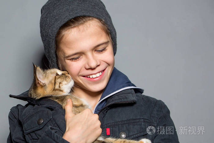 这个男孩在玩猫少年和猫玩得很开心