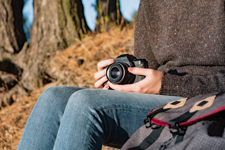 一名女子在室外手持摄像机近距离拍摄照片