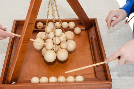 s game with wooden balls. Children play a game with balls. Educa