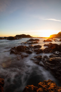 美丽的岩石海景在太平洋海岸在一个充满活力的夏季日落。 在加拿大温哥华岛北部的赫希特海滩拍摄。