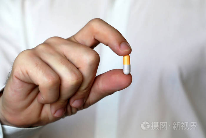 照片 医生握着药丸,男性手,并在胶囊中关闭药物.