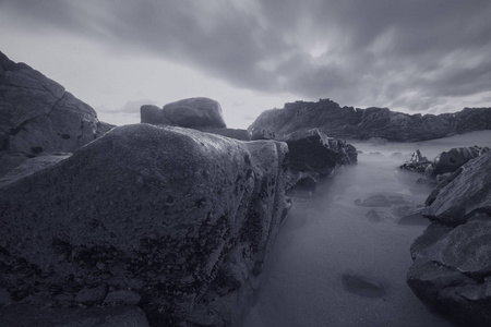 黄昏时穆迪海景。 葡萄牙北部岩石海岸。 转换黑白。 蓝色色调。