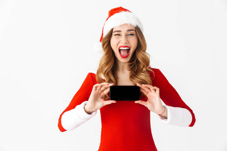 一个美丽的情感女人穿着圣诞服装展示手机的照片。