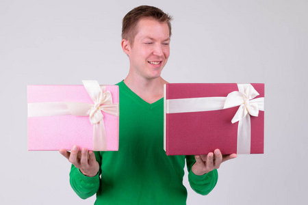 快乐的年轻人比较两个礼品盒准备情人节