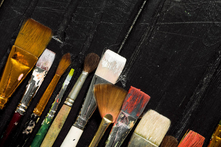 艺术家工具, 画笔在黑色木制背景上排成一排