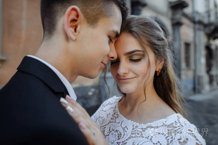 深情的年轻夫妇拥抱在一起互相看着对方