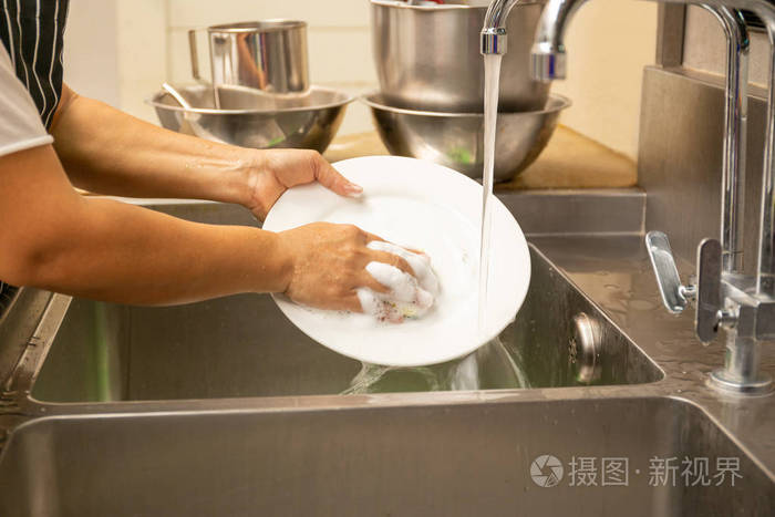 洗手用厨房水槽里的自来水洗脏盘子