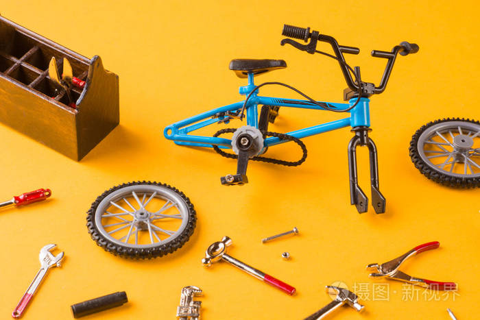 修理自行车。 黄色背景下的零件工具和设备。