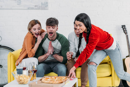 兴奋的多元文化朋友看着美味的披萨