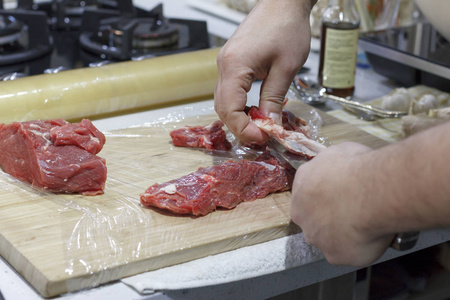 厨师在木板上切下红色的牛肉片