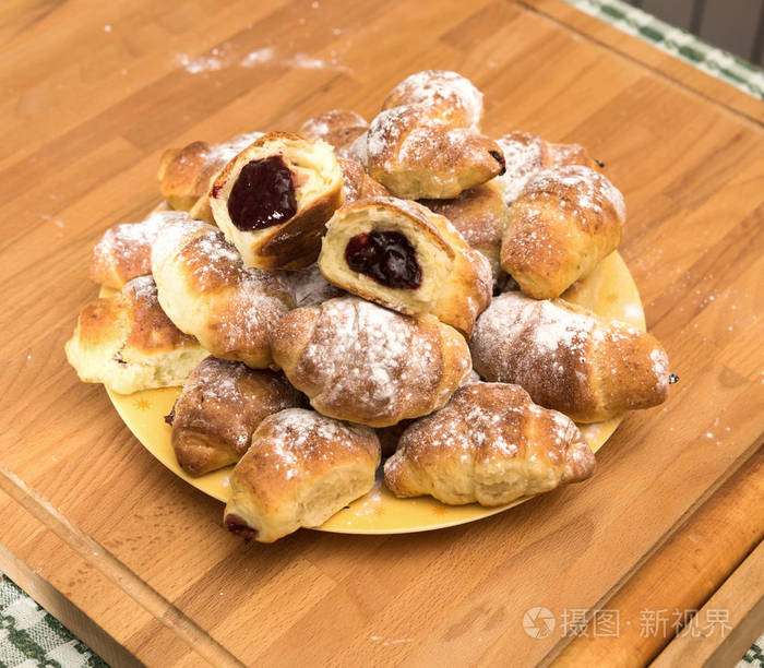 刚出炉的羊角面包,在面包店的木架上撒满糖霜