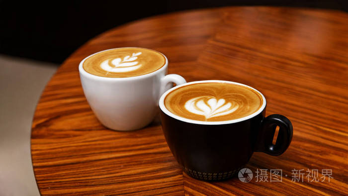 两杯卡布奇诺咖啡放在木桌上肤浅的焦点共空间
