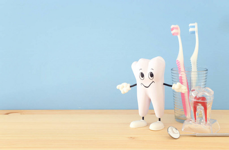 牙科护理工具用于牙医和微笑健康牙齿在诊所。 木制蓝色背景