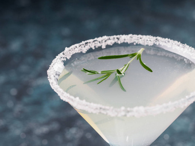 蓝色背景上带有新鲜迷迭香和石灰的酒精尾酒。照片-正版商用图片186mjp