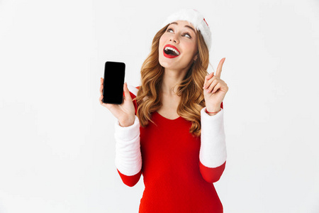 一位身穿圣诞服装展示手机的震惊情绪的女人的照片。