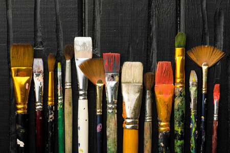 艺术家工具, 画笔在黑色木制背景上排成一排